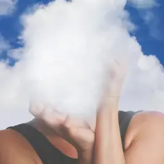 Osoba z twarzą ukrytą w chmurach, symbolizująca mgłę mózgową.