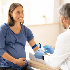 Lekarz pobiera krew od ciężarnej kobiety, aby wykluczyć konflikt serologiczny.