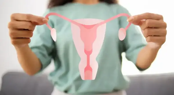 Kobieta trzyma symbol układu rozrodczego, ilustrujący, pcos co to jest i jak wpływa na zdrowie.