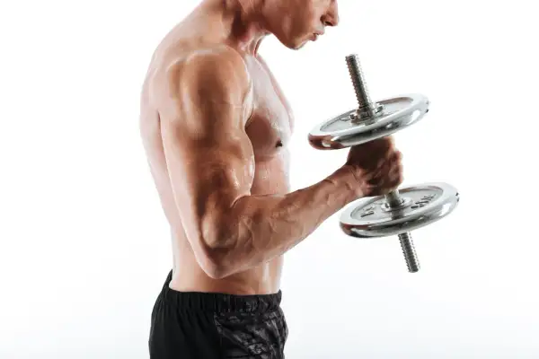 Mężczyzna ćwiczy biceps z hantlem. Widać napięte mięśnie i pot na skórze.